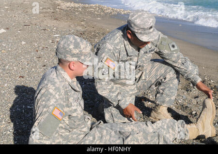 Le sergent-major de l'armée. PerezMartir Noe, un ingénieur responsable de la 40e Division d'infanterie, Joint Task Force Guantanamo, chèques Pvt. Ryan Curtis, la police militaire affecté à la 66e Compagnie de Police Militaire, FOI GTMO, de toute blessure lors d'un recomptage de jour de Thanksgiving à Windmill Beach, Station Navale des États-Unis à Guantanamo Bay, Cuba, le 11 décembre. Les deux a aidé deux victimes séparément qui se débattent dans l'eau en quelques secondes de l'autre. Les soldats sauvent les nageurs en détresse 131211-Z-IB888-022 Banque D'Images