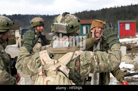 Soldats géorgiens tentent de calmer un villageois qui s'est fâché au sujet d'être détenues pour une recherche aléatoire au cours de la Compagnie Charlie, 23e Bataillon d'infanterie légère de la patrouille du village local à proximité de leur poste de combat interarmées multinationale au Centre de préparation Hohenfels, Allemagne. Le 23e Bataillon d'infanterie légère de style géorgien est à JMRC effectuer une mission de l'exercice de répétition en préparation pour soutenir les opérations de contre-insurrection en Afghanistan dans le cadre de la Géorgie - Programme de déploiement de la Force internationale d'assistance à la sécurité. Marines observer GeorgianE28099s la Compagnie Charlie 23e raid ennemi insurgen LIB Banque D'Images