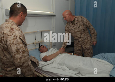 Des Marines américains, le Général David H. Berger, général commandant la 1 Division de marines, (FWD), serre la main de la CPS de l'armée. Christopher A. Regland avec Delta Entreprise, 7/10ème Bataillon de soutien de Brigade, 10e division de montagne à bord Sapadalure Camp dans la province de Helmand, Afghanistan, le 26 février 2012. Décerné à monsieur Berger Regland la Purple Heart pour blessures subies en effectuant des opérations en Afghanistan. (U.S. Marine Corps photo par Lance Cpl. Le CATIE D. Edwards/libéré) Le Général John R. Allen Camp visites Sapadalure 120226-M-S386-013 Banque D'Images