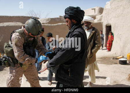 British Royal Marine Commando Lance Cpl. Alan Cahill, gauche, efface les mains d'un homme afghan pour tester des produits chimiques et des résidus de Kajaki, dans la province d'Helmand, en Afghanistan, le 1 mars 2012. Cahill a pris part à une patrouille à la recherche de caches d'armes et des cibles de grande valeur. (U.S. Marine Corps photo par le Cpl. Andrew J. Good/libérés) Enduring Freedom 120301-M-DL630-049 Banque D'Images