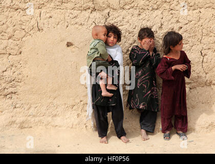 Les enfants attendent de recevoir le programme d'écoute de Radio livres et des radios d'Armée nationale afghane de soldats des forces spéciales et des marines avec les forces U.S. Marine Corps Special Operations Command, au cours d'une patrouille dans le district de Nahr-e Saraj, dans la province d'Helmand le 15 mars. Avec le 1er marines MARSOC Marine Bataillon d'opérations spéciales est rentrée récemment d'un déploiement de neuf mois en Afghanistan, où ils ont commandé la Task Force d'opérations spéciales - à l'Ouest et a supervisé l'une des régions les plus sanglants de l'Afghanistan. (U.S. Marine Corps photo par le Cpl. Kyle McNally/non publié) les FOS-Ouest revient d'deploym Banque D'Images