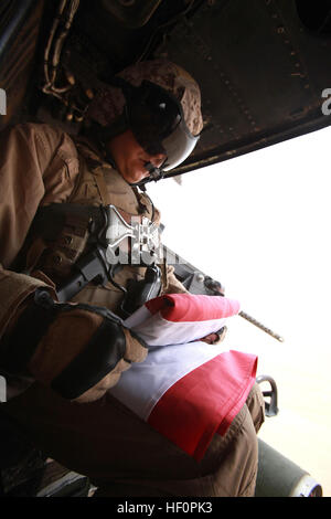 Le Sgt. David Garcia, Chef d'équipe avec l'hélicoptère d'attaque sous-marine et de l'Escadron 369 Glendale (Arizona), les autochtones, les plis d'un drapeau américain tout en volant au-dessus de la province de Helmand, Afghanistan, 9 avril 2012. HMLA-369 envoyé un UH-1Y Huey et un AH-1W Super Cobra à base d'Édimbourg à l'appui de militaires en opérations de contact. HMLA-369 prend en charge les Marines sur le terrain 120409-M-VP013-003 Banque D'Images