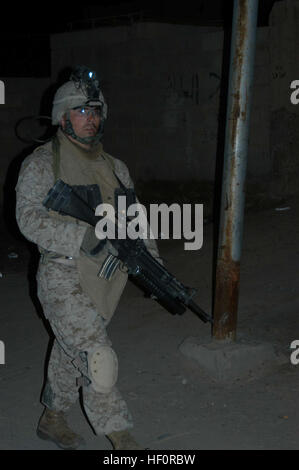 AR RAMADI, en Irak (29 mars 2005) - avec son arme en main, 22 ans, lance le Cpl. Derek J. Reiss, grenadier, 3e Peloton, 2e peloton, Compagnie C, 1er Bataillon, 5e Régiment de Marines, de Chicopee, Massachusetts, garde les yeux ouverts pour les insurgés et d'autres menaces contre les autres Marines en marchant dans une rue de la ville, sombre. Marines avec 2e peloton, Compagnie C, 1er Bataillon, 5ème Marines, a effectué une patrouille de combat de fin de soirée dans une partie de la ville ici où des groupes d'Irakiens, peut-être des insurgés, ont été vues rassemblement après le couvre-feu, qui sont à partir de 10 heures et 6 heures Les Marines découverte talentueuse Banque D'Images