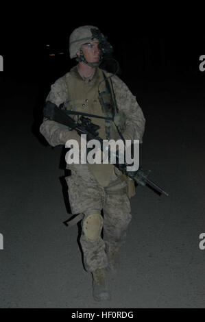 AR RAMADI, en Irak (29 mars 2005) - avec son arme en main, 21 ans, Cpl. James P. Kohler Jr., chef d'équipe, 3ème équipe, 2e peloton, Compagnie C, 1er Bataillon, 5e Régiment de Marines, d'Grandterrace, Californie, garde les yeux ouverts pour les insurgés et d'autres menaces à l'encontre de son équipe tout en patrouille dans une rue de la ville, sombre. Marines avec 2e peloton, Compagnie C, 1er Bataillon, 5ème Marines, a effectué une patrouille de combat de fin de soirée dans une partie de la ville ici où des groupes d'Irakiens, peut-être des insurgés, ont été vues rassemblement après le couvre-feu, qui sont à partir de 10 heures et 6 heures Les Marines découvert Banque D'Images