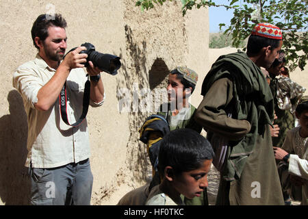 Ben Foley, gauche, caméraman, avec Al Jazeera English News Channel photographies d'enfants afghans locaux dans une école de Kajaki, dans la province d'Helmand, en Afghanistan, le 23 mai 2012. Foley a présenté un rapport sur les forces de la Coalition, transférant la responsabilité de la sécurité dans la région de forces de sécurité nationales afghanes. (U.S. Marine Corps photo par le Cpl. Andrew J. Good/libérés) Al Jazeera News Channel Visite à Kajaki 120523-M-DL630-033 Banque D'Images