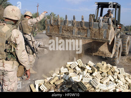 041113-M-1250B-017 Lutafiyah, Iraq (nov. 13, 2004) - UN U.S. Navy Seabee affecté à la 24e Marine Expeditionary Unit (MEU), les chutes de la saleté et de briques dans un trou d'impact sur un pont dans Lutafiyah, de l'Iraq. Les Seabees et marines de la 24e MEU sont la reconstruction du pont après il a été gravement endommagé dans les attaques répétées des militants anti-iraquiens. La 24e MEU est en train de mener des opérations de sécurité et de stabilité dans le nord de la province de Babil ou l'Iraq. U.S. Marine Corps photo par Lance Cpl. Sarah A. Beavers (publié) US Navy 041113-M-1250B-017 UN U.S. Navy Seabee affecté à la 24e Expediti Marine Banque D'Images