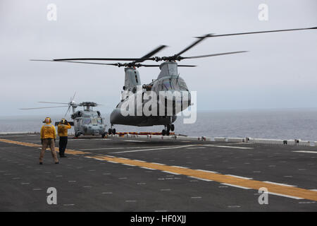 La Marine américaine membre d'équipage de signaux a U.S. Marine Corps CH-46E Sea Knight helicopter attaché à la 15e unité expéditionnaire de Marines à la terre pendant les opérations de vol à bord de l'USS Peleliu, Californie, le 22 juillet 2012.(U.S. Marine Corps photo par Lance Cpl. Danny L. Shaffer/libérés) USS Peleliu 120722-M-BM539-024 Banque D'Images