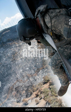 Le Sgt. Chris Boni, Californie chef d'équipe de Garde Nationale d'armée de la 1-140ème bataillon de l'Aviation (Air Assault) sur la base de formation conjointe de Los Alamitos (JFTB), les rejets de l'eau sur la tête tout en luttant contre le feu dans le comté de Kern Rim. L'UH-60 Crew arrosé le rim fire avec un total de 30 111 gallons depuis trois jours tout en luttant contre les incendies dans les complexes de Jawbone soutien de Bureau of Land Management, Kern County fire, et CAL FIRE. Flickr - DVIDSHUB - California et de la Garde nationale aérienne de l'Armée bataille avion blazes (Image 3 de 8) Banque D'Images