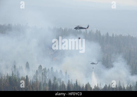 L'armée américaine d'hélicoptères UH-60 Black Hawk affecté à la Garde nationale de Californie goutte eau sur la Ponderosa de forêt près de Redding, en Californie, le 23 août, 2012. L'air de Californie et de l'Armée de gardes nationaux appuient les efforts de lutte contre les incendies dans plusieurs régions de l'état. (Photo par le Sgt. David J. Loeffler) Incendies de Californie 2012 120823-Z-WQ610-016 Banque D'Images