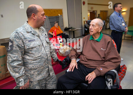 Un résident de Vineland Veterans Memorial Accueil s'entretient avec le conseiller-maître Sgt. Michael Monteith, 177e Escadre de chasse, qui a été parmi les aviateurs de la 108e Escadre situé au Joint Base McGuire-Dix-Lakehurst, New Jersey, et de la 177e Escadre de chasse à Egg Harbor Township, N.J., tant avec le New Jersey Air National Guard, qui ont été rejoints par des élèves de quatrième de l'École de la mer à Linwood, N.J., pour la fête annuelle "ongfest' à la Vineland Veterans Memorial Home, Vineland, N.J., 13 décembre 2012. C'est la 12ème année, les ailes ont visité la maison et à l'arrivée, les aviateurs et de quatrième année étaient iss Banque D'Images