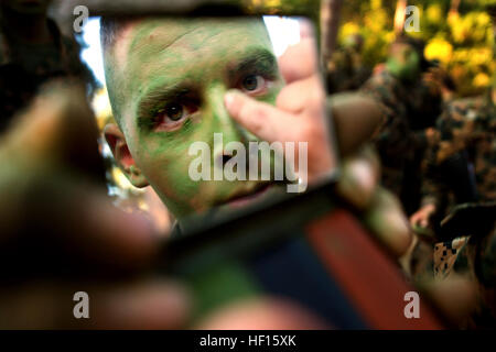 Une formation d'infanterie bataillon élève applique camoflauge peinture pour le visage et le cou avant de commencer la semaine de patrouille près du Camp Geiger, N.C., le 28 octobre, 2013. Semaine de patrouille est un événement de formation de cinq jours qui enseigne aux élèves de l'infanterie, défensive et offensive de base des techniques de patrouille. La Compagnie Delta est la première entreprise de formation d'infanterie d'intégrer pleinement les femmes dans la Marine l'ensemble d'un cycle de formation. Cet avenir sera comanies et évaluer les performances de l'homme marines dans le cadre de recherches en cours sur la lutte contre l'ouverture des champs liés à l'emploi pour les femmes. (U.S. Marine Corps photo par le Sgt. Tyler L. Main Banque D'Images