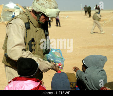 061208-M-8974P-013 Village Coréen Camp, l'Iraq (31 déc. 8, 2006) - commandant du bataillon logistique de combat, 15, 15e Marine Expeditionary Unit, le Lieutenant-colonel Henry M. Hyams, les mains des bonbons aux enfants dans un camp de réfugiés soudanais. 15e MEU (SOC) est déployée avec I MEF (FWD) à l'appui de la guerre mondiale contre le terrorisme dans la province d'Al Anbar en Irak. U.S. Marine Corps photo de la FPC. Timothy (paroisse) PARUTION US Navy 061208-M-8974P-013, commandant du bataillon logistique de combat 15, 15e Marine Expeditionary Unit, le Lieutenant-colonel Henry M. Hyams, les mains des bonbons aux enfants Banque D'Images