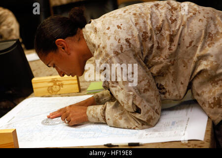 Le lieutenant de la Marine américaine Leticia D. banquier, un médecin de l'Escadron de soutien de l'aile Marine avec 271 parcelles, coordonnées sur une carte pendant un cours de navigation terrestre au Camp Sapadalure, province de Helmand, en Afghanistan, le 9 mai 2013. Le cours fait partie des exigences requises pour les marins d'atteindre le Fleet Marine Force marine terminal. (U.S. Marine Corps photo par le Sgt. Gabriela Garcia/libéré) La Marine américaine marins travailler à leur badge Fleet Marine Force avec l'aide de Marines des États-Unis 130509-SA-M716-022 Banque D'Images