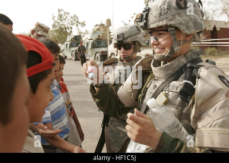 16 mai 2007, Al Madinah, Iraq, spécialiste de l'Armée de Taryn Emery un Lyle, natif du Minnesota distribue des bonbons aux enfants irakiens. Les citoyens de Al Madinah comme Siyahiyah profiter des soins médicaux fournis par des soldats de la 1ère Division de l'armée irakienne l'exécution d'une mission médicale coopérative (MEC) avec l'aide de mesure Compagnie, 2e Bataillon interarmes du 136e Régiment d'infanterie, 2e Groupe Logistique maritime (avant). 2ème MLG est déployée au sein de l'Al Anbar province afin de développer les forces de sécurité iraquiennes, faciliter le développement de la règle de droit par le biais du gouvernement démocratique Banque D'Images