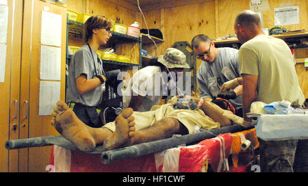 Une équipe de secouristes avec 1er Bataillon, 6e Régiment d'artillerie, d'évaluer un patient sur 21 juillet 2013, à la base d'opérations avancée de Spin Boldak, Afghanistan. Le patient a été victime d'un bombardement à Spin Boldak, une ville voisine. (U.S. Photo de la Garde nationale par la CPS. Jovi Prevot) des soldats américains prendre soin des blessés Afghans 130721-Z-IX952-139 Banque D'Images