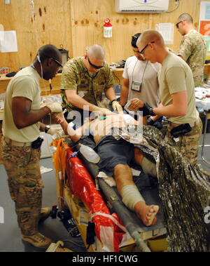 Le sergent de l'armée américaine. Brandon Green (centre) et une équipe de secouristes avec 1er Bataillon, 6e Régiment d'artillerie, d'évaluer un patient sur 21 juillet 2013, à la base d'opérations avancée de Spin Boldak, Afghanistan. Le patient a été victime d'un bombardement à Spin Boldak, une ville voisine. (U.S. Photo de la Garde nationale par la CPS. Jovi Prevot) des soldats américains prendre soin des blessés Afghans 130721-Z-IX952-184 Banque D'Images