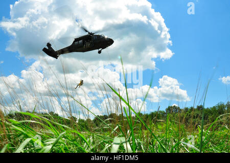 Le sergent de l'armée américaine. Kevin Imhof, un vol medic de Magnolia, Del., est abaissé d'un UH-60 Black Hawk pendant la formation treuil de sauvetage près de la Chesapeake and Ohio Canal dans le comté de New Castle, Delaware, le 4 août 2013. Imhof est membre de la compagnie, 1er Bataillon, 126e Régiment d'aviation (Air Ambulance), Texas Army National Guard. (U.S. Photo de la Garde nationale par le sergent. Brendan Mackie/libéré) des soldats de l'aviation d'opérations treuil de sauvetage pratique 130804-Z-DL064-269 Banque D'Images