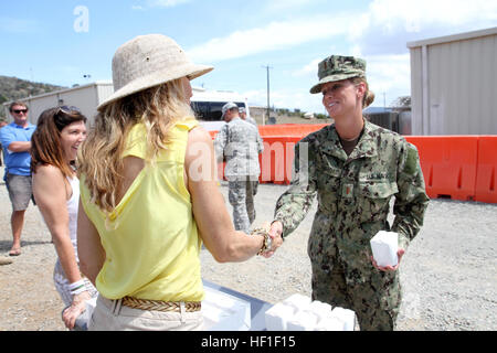 Navy Ensign Sarah Alexander, une infirmière avec le groupe médical commun, serre la main de Hollis Wilder, propriétaire de Sweet ! Par Holly cupcake stocke et trois fois champion de Food Network's Cupcake Wars, lors de l'obtention d'un cupcake, 29 août 2013 à la base navale américaine de Guantanamo, à Cuba. Army National Guard (photo par le Sgt. Cassandra Monroe/120e Détachement des affaires publiques/JTF-GTMO Affaires publiques) friandises 130828-Z-FT114-142 Banque D'Images