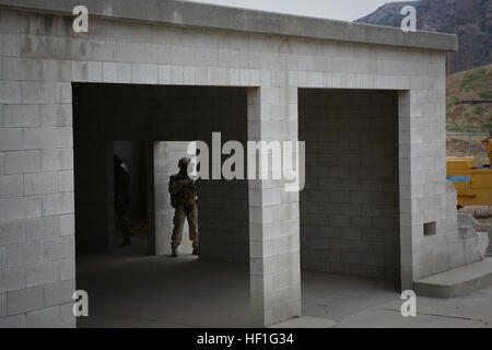 Riflemen avec Delta Entreprise, 1er Bataillon, 1e Régiment de Marines, assurer la sécurité à une maquette de la station de gaz comme les autres Marines Delta Co. un bâtiment d'assaut pendant un cours de dirigeants urbains à un scénario de formation opérations militaires sur terrain urbain mondial ici, le 19 septembre 2013. Les Marines a fourni une garantie d'un bâtiment à l'installation et alors agressé un bâtiment voisin avec les acteurs armés, joué par d'autres marines, qui menaçaient la sécurité générale. Les Marines, les forces amies et ennemies, utilisé des munitions Simunition tours - simulés qui contient de la peinture pour marquer upo Banque D'Images