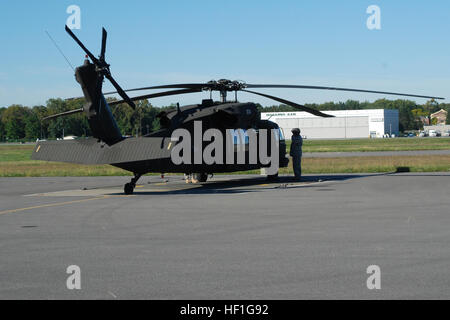 Un soldat américain avec la Garde Nationale de New York mène une inspection prévol sur un hélicoptère Blackhawk UH-60 affecté à la Compagnie Alpha, 3e Bataillon, 142e Régiment d'aviation avant de partir un vol dans la région de Latham, NY, 25 septembre 2013. L'hélicoptère était en route pour Fort Hood, au Texas, pour compléter la formation avec des soldats affectés à la 42e Brigade d'aviation de combat avant le déploiement au Koweït. (U.S. Photo de Garde Nationale d'armée par le Colonel Richard Goldenberg/libérés) Départ de formation 130925-DE-Z820-025 Banque D'Images