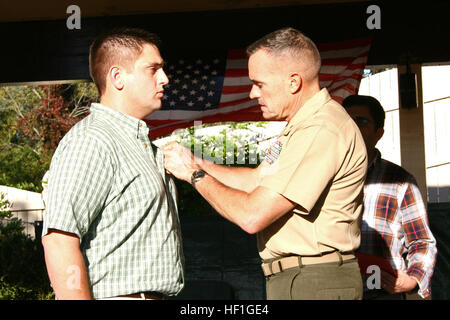 Le général de brigade Vincent A. Coglianese, général commandant, 1er Groupe logistique maritime, les broches a Purple Heart sur son fils, Ferdinand Coglianese, un vétéran de la Marine, le 28 septembre 2013, à Schwenksville, Pa. pendant son déploiement au 2e Bataillon de Génie de Combat, 2e Division de marines, dans la province de Helmand, Afghanistan, lance le Cpl. Ferdinand Coglianese a été touché par un engin explosif improvisé sur une patrouille de logistique de combat de routine. (Avec la permission de la photo de Michelle Bardzil) 1er MLG commandant général awards Purple Heart en fils 130928-M-VZ265-797 Banque D'Images