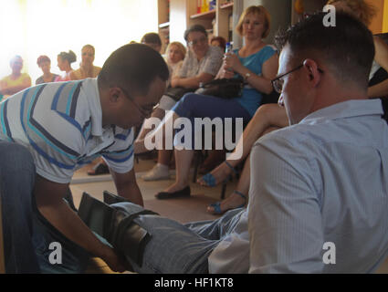 Hospital Corpsman 2e classe Jascha Roux montre la façon d'attelle et immobiliser un genou blessé sur HM2 Ryan Boze pendant un cours de premiers soins de base dispensés par corpsmen de la Shock Trauma peloton, Force de rotation 12 de la mer Noire à Constanta, Roumanie 25 Juillet. La classe a été enseigné à des bénévoles d'un centre de placement locaux des besoins spéciaux pour les adultes et les enfants. La Force de rotation de la Mer Noire 12 est un groupe de travail air-sol marin spécialisé avec des capacités d'intervention de crise déployés dans la région pour améliorer l'interopérabilité et de promouvoir la stabilité régionale. BSRF Corpsmen enseigner les premiers secours à vo local Banque D'Images