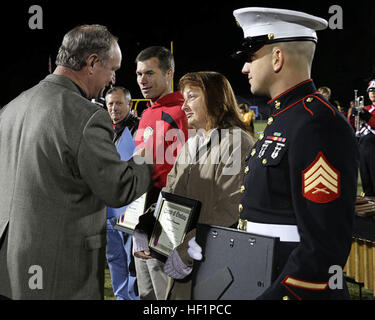 Le maire de Jacksonville Sammy Phillips (à gauche) parle avec un premier intervenant qui ont aidé le Sgt. Ty M. Baker Jr. (droite) sauver la vie de l'homme local à un match de football de l'école au cours d'une cérémonie de remise de prix pour les premiers intervenants à Jacksonville, NC, le 25 octobre 2013. Baker et les deux personnes qui ont contribué à sauver la vie de Wayne Allen ont reçu des certificats d'hébergement de la ville de Jacksonville et Onslow comté, ainsi qu'une plaque de la Jacksonville Senior High School Booster Club pendant un match de football. Baker est un technicien d'entretien automobile Entretien avec 2e Bn., 25 Régiment de logistique de combat, 2 Banque D'Images