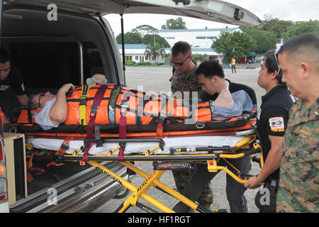 VILLAMOR AIR BASE, République des Philippines- Les membres des Forces armées des Philippines, les membres du service des États-Unis et le personnel médical de Centre médical de Makati, ascenseur, une victime blessée de super typhon Haiyan/Yolanda dans une ambulance le 18 novembre à Villamor Air Base. Jusqu'à ce point les blessés citoyens dans le besoin d'assistance médicale ont été transportés en ambulance à l'Centre médical de Makati. Le rôle des forces militaires des États-Unis au cours de toute l'aide humanitaire étrangère est l'événement pour répondre rapidement avec l'appui pour aider à atténuer les souffrances humaines et de prévenir d'autres pertes de vie et mitig Banque D'Images