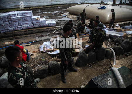 Les membres de la Police nationale des Philippines d'une force d'action spéciale de recueillir l'eau d'un système de purification de l'eau à l'atterrissage MacArthur Parc National Memorial le 21 novembre lors de l'opération Damayan. Le typhon Haiyan a frappé les Philippines le 7 novembre avec des vents soutenus estimée à près de 200 km/h et des rafales près de 230 mph. Près de 1 800 tonnes de fournitures ont été livrées, dont plus que 17 500 personnes ont été évacuées de la provinces touchées lors de l'opération. Système de purification constitue une resource 131121-M-GX379-056 Banque D'Images