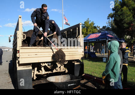 131207-Z-IB797-175 Tony Horner et Vince Parga, ingénieurs avec moteur 11 de la Benicia Pompiers aider à décharger le paillis à partir d'un véhicule tactique pendant la Benicia Armory Projet d'Embellissement avec le 749e Bataillon de soutien au maintien en puissance de combat le 7 décembre. Le paillis a été utilisé dans la nouvelle usine lits conçus par des membres de troupe de scouts 8 travaillant sur leurs tâches d'Eagle Scout. (U.S. La Garde nationale de l'armée photo/cps. James Wilton/libérés) Soldats, communauté locale unissent leurs forces pour l'Armory projet d'embellissement 131207-Z-IB797-175 Banque D'Images