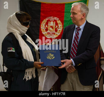 Mark Mitchell de l'Agence américaine pour le Développement International, présente Bibi Aisha de l'enquête criminelle de la Police nationale afghane, un ministère des femmes de courage Zaboul au prix de base d'Apache, l'Afghanistan, le 15 février 2014. Bibi a été nommé pour l'award pour son travail progressiste comme une femme agent de police dans la province de Zaboul, et d'assurer la sécurité et d'encouragement pour les autres femmes en Afghanistan. (U.S. Photo de l'armée par le Cpl. Mariah meilleur) les femmes afghanes de Courage à l'honneur dans Zabul 140215-Z-TF878-696 Banque D'Images