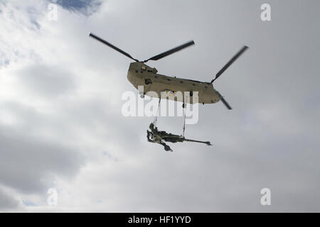 Un obusier M177 155mm est transportée par un CH-47 Chinook par temps froid, les opérations de charge de l'élingue au Camp Grayling Centre mixte, au Michigan, le 1 mars 2014. Michigan (photo de la Garde nationale par le sergent. Kimberly Bratic/libérés) Michigan Garde nationale mène la charge sous élingue par temps froid et l'exercice de tir réel d'obusiers 140301-LE-Z308-031 Banque D'Images