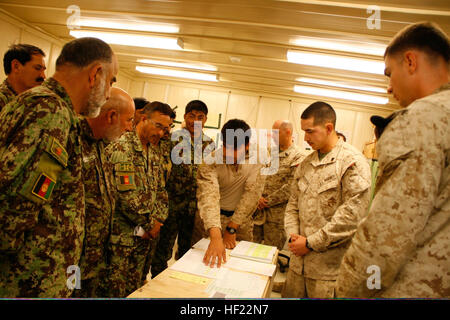 Corps des Marines des États-Unis Les Cpl. Jonathan Arroyo, droite, et Christopher Mosqueda, deuxième à partir de la droite, les deux techniciens en télécommunications du bataillon logistique de combat 7, enseigner aux soldats de l'Armée nationale afghane avec le 215e Corps canadien sur la présentation des demandes d'entretien pour les équipements nécessitant des réparations à Sapadalure le Camp dans la province de Helmand, Afghanistan, 6 avril 2014, dans le cadre d'une révision du curriculum pour une prochaine communication Cours de maintien de l'électronique. Les forces de la Coalition a continué à former les forces de sécurité nationale afghanes (FSNA) en prévision de la période de transition prévue à la pleine responsabilité des FSNA pour Af Banque D'Images