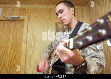 Le Lieutenant Cmdr. Frank Villaume, de St Paul, Minn., un médecin de médecine d'urgence, du bataillon logistique de combat 7, joue de la guitare pour une nuit de Pâques à bord de masse Sapadalure Camp, province de Helmand, Afghanistan, le 19 avril 2014. L'archevêque Timothy P. Broglio, gauche, qui dirige le Diocèse catholique romain pour les services militaires, a effectué la veille. (U.S. Marine Corps photo par le Cpl. Josué les jeunes) les membres de célébrer la Semaine Sainte en Afghanistan 140419-M-PF875-001 Banque D'Images