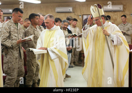 L'archevêque Timothy P. Broglio, droite, qui dirige le Diocèse catholique romain pour les services militaires, et le lieutenant-colonel Brian Ray, centre, l'aumônier catholique du Commandement régional (Sud-ouest), effectuer la veille de Pâques à bord de masse Sapadalure le camp, dans la province d'Helmand, en Afghanistan, le 19 avril 2014. La masse a inclus plusieurs baptêmes et des confirmations dans la foi catholique. (U.S. Marine Corps photo par le Cpl. Josué les jeunes) les membres de célébrer la Semaine Sainte en Afghanistan 140419-M-PF875-014 Banque D'Images