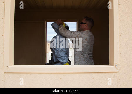 Les Marines américains mis sur les combinaisons de matières dangereuses en préparation à la recherche de contaminants dans une simulation de défense chimique, biologique, radiologique et nucléaire au scénario à 051 Gamme Marine Corps Air Ground Combat Center, Twentynine Palms, Californie, le 23 avril 2014. Superviseur de neutralisation des explosifs conduite de cours de formation avancée dans les procédures concernant les polluants. (U.S. Marine Corps photo par Lance Cpl. Rebecca Floto/MAGTAFTC HQBN USMC/Caméra de combat) Parution Explosive Ordnance Disposal Cours Superviseur 140423-M-IJ860-070 Banque D'Images