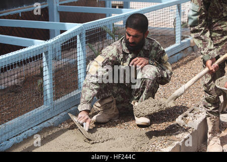 Un soldat de l'Armée nationale afghane avec le 215e Corps canadien s'étend du béton pour une mosquée à bord, l'Afghanistan, le Camp de Shorabak 1er mai 2014. Corps des marines avec les surplus de matériaux doués de l'École de combat du Camp Sapadalure pour les soldats de l'ANA pour les aider à terminer la reconstruction d'une mosquée qui a été détruit lors d'une tempête de février. (U.S. Marine Corps photo par le Cpl. Cody Haas/ libéré) soldats de l'ANA reconstruire mosquée 140503-M-YZ032-917 Banque D'Images