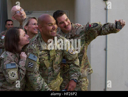 Le sergent de l'Armée américaine à la retraite. Saul Martinez pose pour une avec le personnel de selfies Craig mixte Hôpital Théâtre, l'aérodrome de Bagram, en Afghanistan, au cours de l'opération Bon Quitter le 28 mai 2014. Le programme est une initiative de la Fondation de la première troupe qui permet aux militaires qui sont gravement blessés dans l'exercice de leurs fonctions pour revenir à la bataille et les laisser à leurs propres conditions. En 2007, Martinez était dans le véhicule de tête d'un convoi à Salman Pak, l'Irak, lorsqu'un PEF a explosé. En conséquence il est devenu amputée des massifs avec perte de tissu sur le dos et un traumatisme crânien. (U.S. Photo de l'armée par le sergent. Ly Banque D'Images