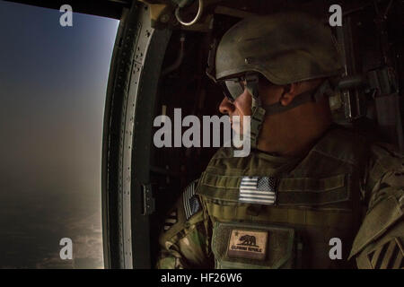 Le sergent de l'Armée américaine à la retraite. Saul Martinez views le paysage de l'Afghanistan à partir d'un hélicoptère Black Hawk, le 28 mai 2014, au cours de l'opération de sortie appropriée, d'une troupe d'abord l'initiative de la fondation qui permet aux militaires qui sont gravement blessés dans l'exercice de leurs fonctions pour revenir à la bataille et les laisser à leurs propres conditions. En 2007, Martinez était dans le véhicule de tête d'un convoi à Salman Pak, l'Irak, lorsqu'un projectile explosivement formé a explosé. En conséquence, il est devenu une amputée des massifs avec perte de tissu sur le dos et un traumatisme crânien. (U.S. Photo de l'armée par le sergent. Lyndsey Prax) blessés afin Banque D'Images