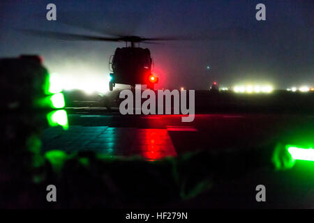 Le Sgt. Joann Duclose de première classe, un conseiller principal en ressources humaines de l'Aviation sergent 642e Bataillon de soutien, donne un UH-60 Black Hawk le vol stationnaire du signal du bras comme deux autres soldats accrocher un poids au cours de la nuit la charge sous élingue avec formation d'aviateurs du 3 e Bataillon, 142e Bataillon d'hélicoptères d'assaut, le 5 juin 2014, au Camp Buehring, le Koweït. La 642e et 142e, tant dans le cadre de la 42e Brigade d'aviation de combat, la Garde Nationale de New York, sont déployés au Koweït dans le cadre de l'opération Enduring Freedom. (New York) La Garde nationale de l'armée photo par le Sgt. Harley Jelis/libérés) 642e Bataillon de soutien à l'aviation nuit Banque D'Images