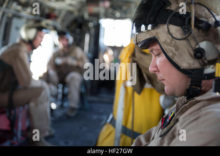 Le Capitaine Ian Gough, un CH-46E Sea Knight pilote de l'hélicoptère maritime avec l'Escadron d'hélicoptère moyen 774, 4e l'aile Marine, Marine, promenades de la Réserve des Forces canadiennes en tant que passager dans un CH-46E Sea Knight helicopter avant son vol au cours d'un vol de familiarisation de la région dans le cadre de l'exercice d'entraînement intégré 4-14 ici 7 juin 2014. Le vol a été la première opération de vol effectuées au cours de l'exercice de deux semaines et la première fois les pilotes de l'escadron avait volé dans un environnement désertique depuis l'année dernière, l'ITX. L'ITX est la plus grande réserve Marine Corps d'entraînement avec plus de 4 000 Marines américains et Banque D'Images