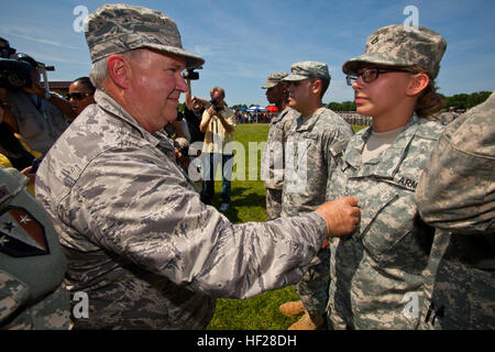 Le brig. Le général Michael L. Cunniff, gauche, l'adjudant général du New Jersey, fait la promotion de Pvt. Zabreena Dickman de soldat de première classe au cours de la cérémonie de départ pour le 1-114ème Infantry, New Jersey Army National Guard, à Doughboy, champ Joint Base McGuire-Dix-Lakehurst, N.J., le 18 juin 2014. Sept soldats dont ont été promus à la cérémonie. Les près de 450 Citizen-Soldiers du Woodbury, Freehold et Mt. Holly armories va assurer le commandement et le contrôle de trois sociétés effectuant de la Force de sécurité et de protection de la force de sécurisation de sites critiques ; de fournir une surveillance pour la planification de la mission Banque D'Images