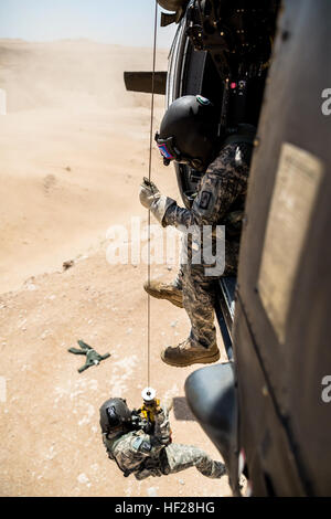 La CPS. Mouyos Nicholas, un médecin de vol, est abaissée par un palan à une victime simulée par la CPS. Giles Dunlop, chef d'équipe, au cours d'un exercice de récupération du personnel entre un UH-60 Black Hawk piloté par la société C, 1er Bataillon, 214e Air Ambulance, 42e Brigade d'aviation de combat (cabine), et une Force aérienne koweïtienne hélicoptère Puma SA 330 le 19 juin 2014, au Koweït. 42e CAB et forces koweïtiennes effectuent régulièrement des joint aviation partenariats pour accroître leur capacité à répondre à toute urgence. La 42e CAB, New York, de la Garde nationale de l'armée est déployée au Koweït dans le cadre de l'opération Enduring Freedom. (New York) Nat de l'armée Banque D'Images