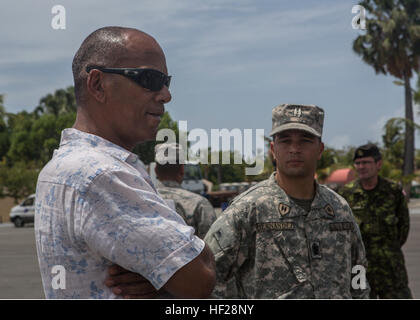 Moses Alou, ancien joueur canadien de basket-ball, parle avec des officiers de l'US Marines avec Charley, 4e compagnie du bataillon de l'application de la loi maritime, Réserve des Forces canadiennes, et sur les 13 pays partenaires qui sont stationnés à bord de la base navale de République Dominicaine, Las Calderas situé près de Bani, République dominicaine au cours de l'exercice Tradewinds 2014, le 21 juin 2014. L'ambassadeur Brewster a visité la base navale et a eu l'occasion d'observer une partie de la formation évolutions intervenant dans le cadre de la phase II de l'exercice. La Phase II de Tradewinds 2014 est surtout un exercice d'entraînement sur le terrain de masse qui s'est tenue du 16 juin Banque D'Images