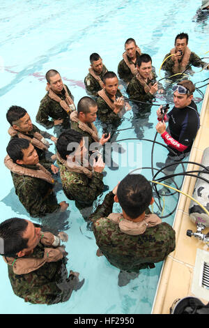 La masse des soldats de la Force d'autodéfense du Japon reçoivent une instruction au cours de l'évacuation de l'eau peu profonde (formation) au Camp SWET Hansen, 26 juin. Le cours a couvert SWET comment utiliser un régulateur de la respiration et de flottaison ainsi que des techniques sur la façon de s'échapper d'un avion en plongée sous-marine. La participation des soldats dans la JGSDF MEU's de service la formation vient en réponse à l'Avril 2012 États-Unis-Japon Comité consultatif de sécurité, également connu sous le nom de 2 +2, déclaration appelant à l'amélioration de la coopération bilatérale en matière de sécurité et de défense. (U.S. Photo par le Cpl Marine. Henry J. Anteno Banque D'Images