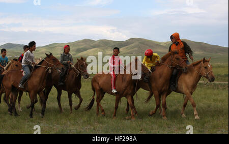 Enfants mongols montent leurs chevaux avant de terminer une course de 22 km lors d'une mini-festival Naadam le 27 juin à cinq Hills Zone de formation, Taiwan, en Mongolie, au cours de l'effort KHAAN QUEST 2014. Naadam mongol traditionnel est un festival qui se déroulera du 11 au 13 juillet chaque été. Il se compose de lutte mongole, les courses de chevaux et le tir à l'ARC. Comme une démonstration de l'hospitalité pour les clients, les Mongols souvent l'hôte d'une mini-version de ce festival. KQ14 est normalement prévu à l'exercice multinational, organisé chaque année par les forces armées mongoles et co-parrainé cette année par l'armée américaine, Pacifique et les forces du Corps des Marines des États-Unis, Pa Banque D'Images