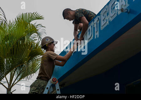 La Marine américaine Constructionman Strozewski Serena Builder, un bataillon de construction de Seabee Maintenance Unit 202, redessine le nom de la bibliothèque locale dans le district d'Izabal avec l'aide de la Brigada guatémaltèque de Infanteria de Marina (BIM) d'ingénieurs. La BIM avec leurs homologues américains à rénover la Hemeroteca Municipal Corporacion 74-78 dans le cadre d'un projet humanitaire à Puerto Barrios, Guatemala, 14 août 2014. Les Marines et les marins sont d'aider à rénover les bâtiments à l'appui de Partenariat Sud Gare 2014, un exercice interarmées axé sur l'objet ma Banque D'Images