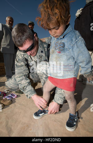 CAMP DE RÉFUGIÉS de Parwan, Afghanistan -- Le Lieutenant-colonel (Dr.) Thomas Knolmayer aide une fille afghane essayer sur fait don de chaussures à l'aide humanitaire d'une visite ici. Les vêtements, chaussures, manteaux et couvertures mis dans le camp de réfugiés étaient des dons faits à l'opération soins par les citoyens américains. Les dons ont augmenté après un 5-year-old Afghan est arrivé à l'hôpital Théâtre Craig avec les chaussures. Le Colonel Knolmayer a demandé à sa femme d'envoyer une paire de chaussures de leur fils pour le garçon. Qui a commencé une chaussure et collecte de vêtements pour les personnes dans le camp de réfugiés et d'autres communautés en Afghanistan. Le colonel est un Knolmayer genres Banque D'Images
