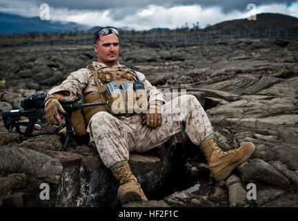 Le sergent des Marines des États-Unis. Jonathan MCINTYRE, un champ Wireman attribué à 1er Bataillon, 12e Régiment de Marines, Charlie batterie, se repose sur les vestiges de coulées après une mission de tir direct à bord d'entraînement de Pohakuloa (ATP), New York, Septembre 2nd, 2014. Les membres du 1er Bataillon du 12ème de marine (1/12), sont l'amélioration de leurs compétences de tir d'appui direct à l'appui de l'opération Spartan Fury. (U.S. Marine Corps photo par Lance Cpl. Victor A. Mancilla/libérés) Fury 2014 spartiate, 1-12 140902-M-AU949-002 Banque D'Images