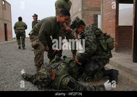 Maître de 2e classe Gabriel Besa, gauche, d'une marine hospital corpsman avec des Groupe de travail Maritime Aérien Au sol, du Sud et originaire de Pearland, Texas, fournit un environnement stressant en criant à la Marine péruvienne pour l'exercice final d'un cours de Combat Gareautrain lors d'une coopération en matière de sécurité dans le théâtre d'échanges bilatéraux à Base du Corps des marines péruvienne Ancon, Pérou, 2 septembre 2014. Le TSC est composé d'événements pour inclure plusieurs échanges bilatéraux d'un traitement médical, la détection des explosifs improvisés, les arts martiaux mixtes et combattre l'adresse au tir. Grâce à une coopération étroite, les États-Unis une Banque D'Images